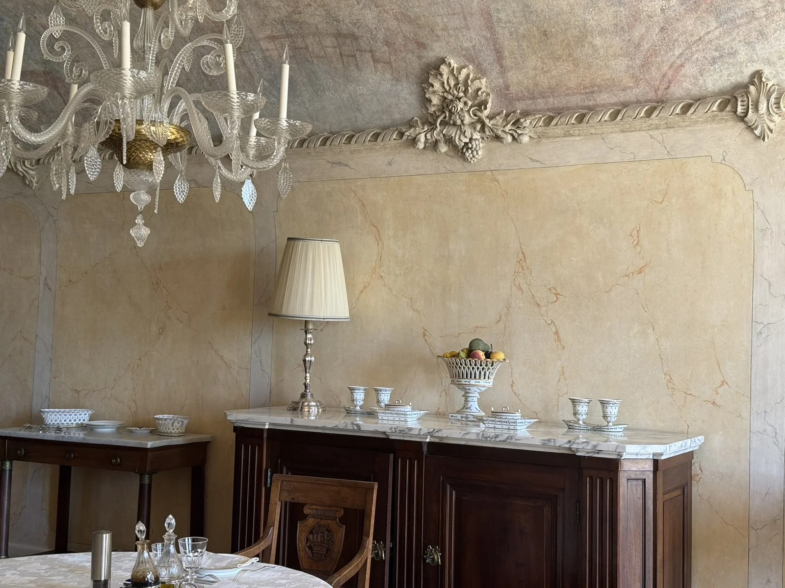 Intérieur aux murs décorés de faux marbre, avec corniches et cheminée